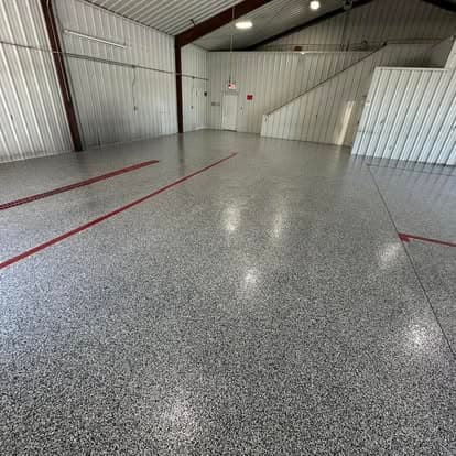 Spacious industrial interior with glossy epoxy-coated flooring and red stripe markings.
