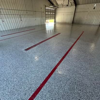 Spacious industrial garage with polished gray epoxy floor and red safety lines.